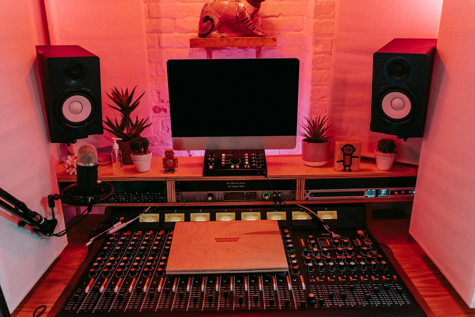 Faceless YouTube creator's studio setup with monitor, mixer, and microphones for content creation.