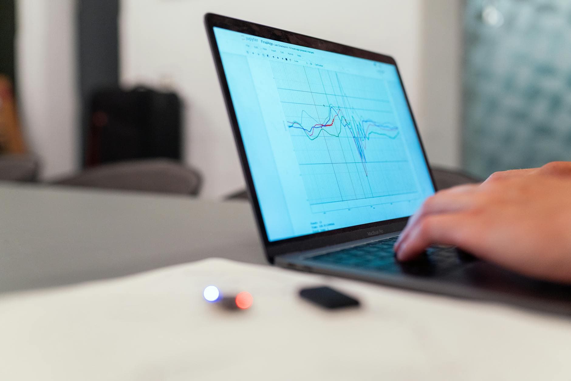 Hands typing on a laptop displaying analytics graphs for faceless YouTube channel content strategy.