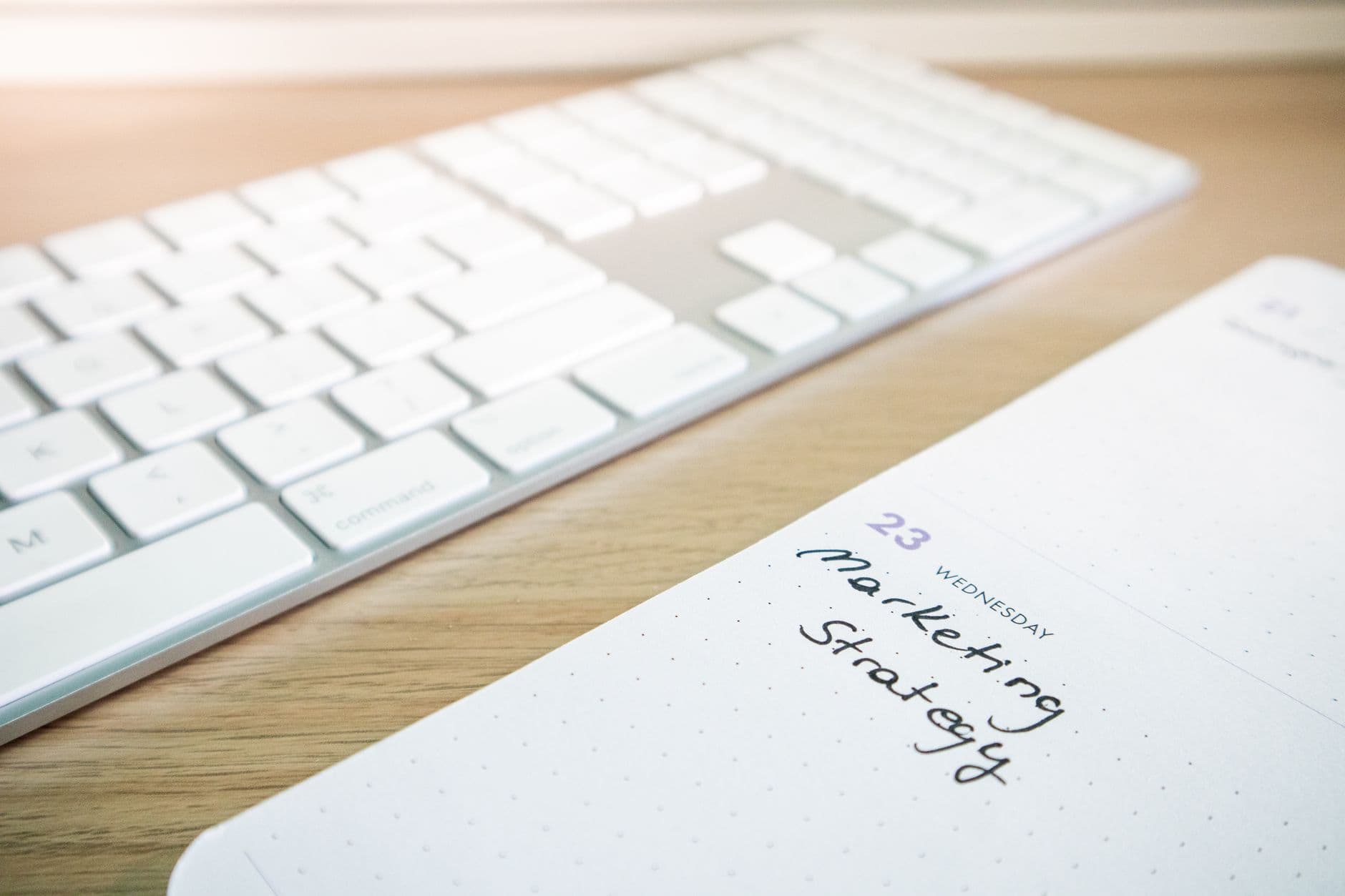 Faceless YouTube creator's planning notebook and keyboard for marketing strategy.