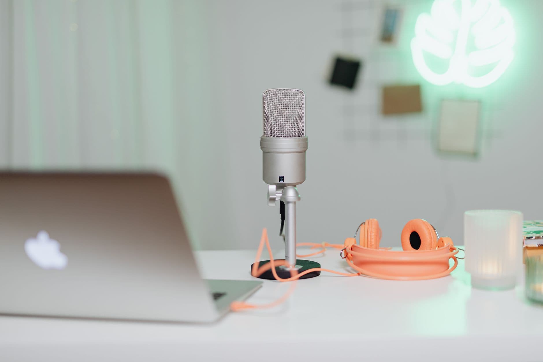 Faceless YouTube creator's desk with laptop, microphone, and headphones for content planning.
