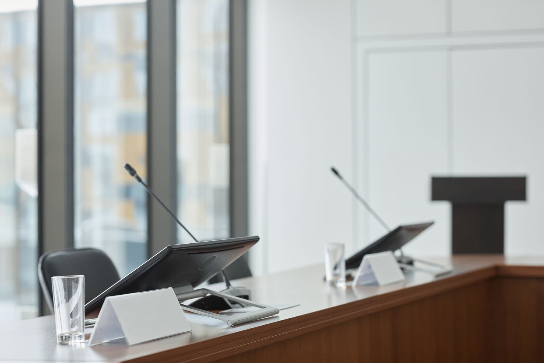 Conference room setup with microphones, monitors, and podium for content creation.