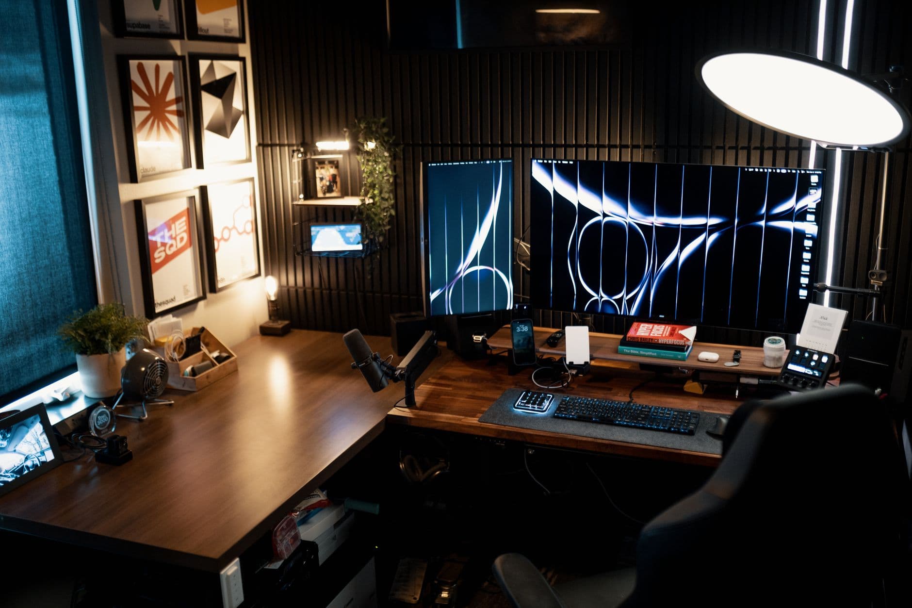 Faceless YouTube creator's desk with dual monitors showing video editing timeline and graphics.