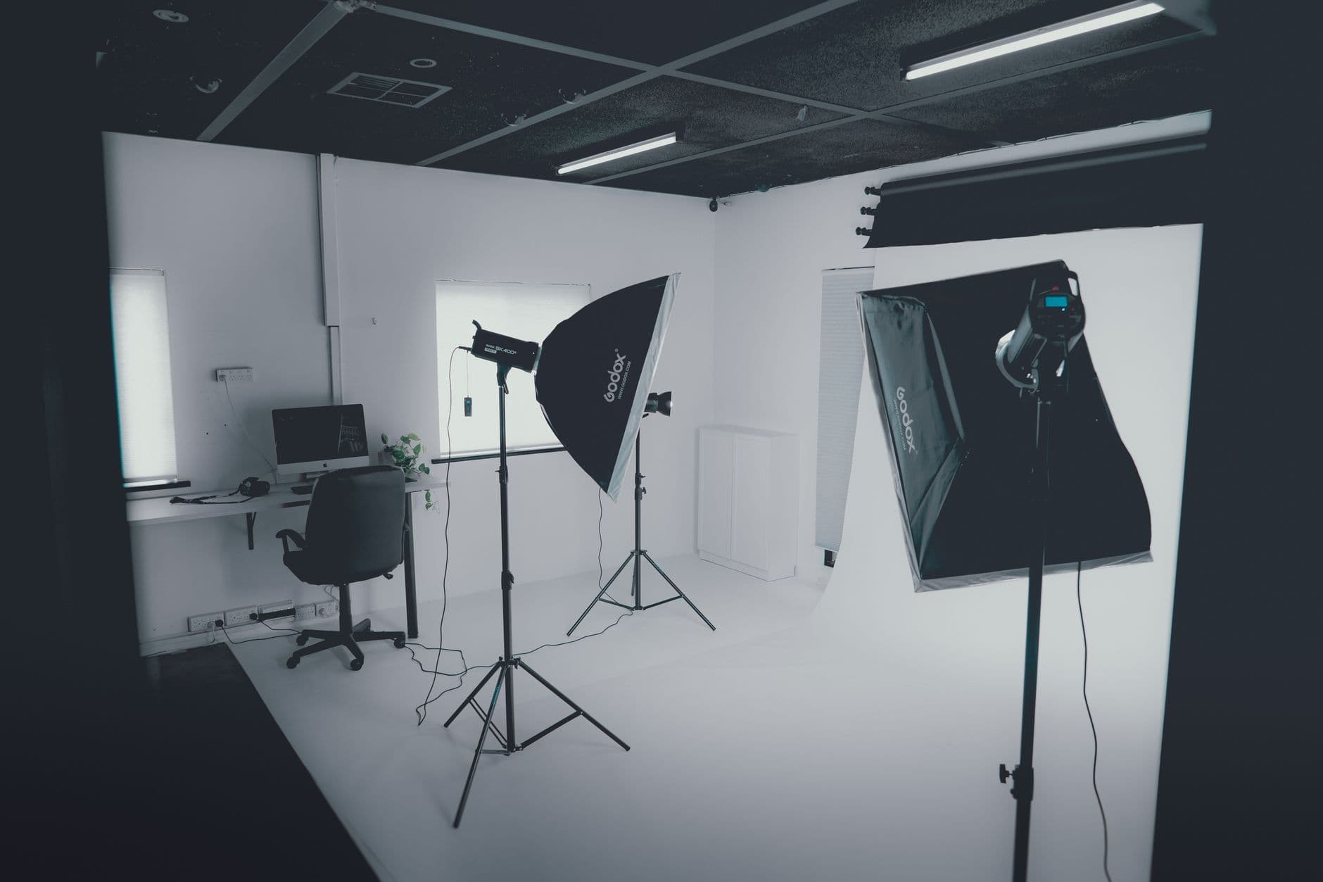 Empty recording studio with lighting equipment and a desk with a computer, ideal for faceless YouTube content creation.