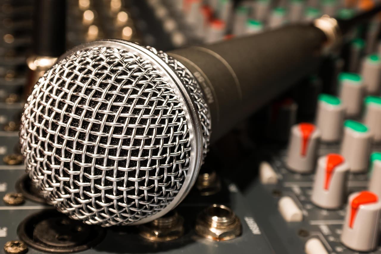 Close-up of a professional microphone on a sound mixing board, ideal for content creation workflow.