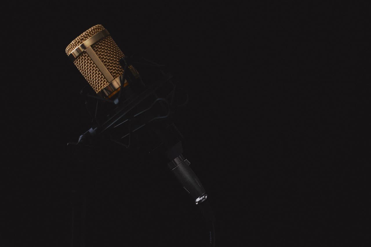Close-up of a golden microphone on a stand, ideal for faceless YouTube creator audio setup.
