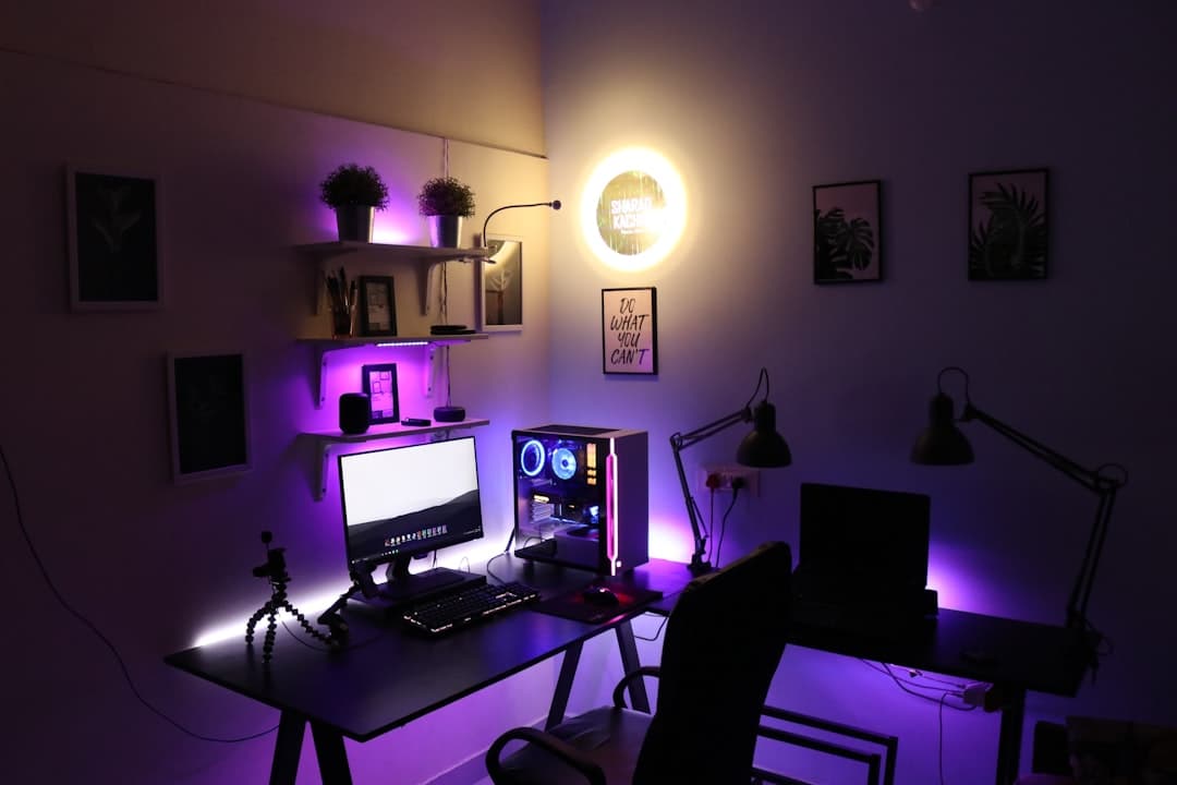 Faceless YouTube creator's desk setup with multiple monitors and RGB lighting.