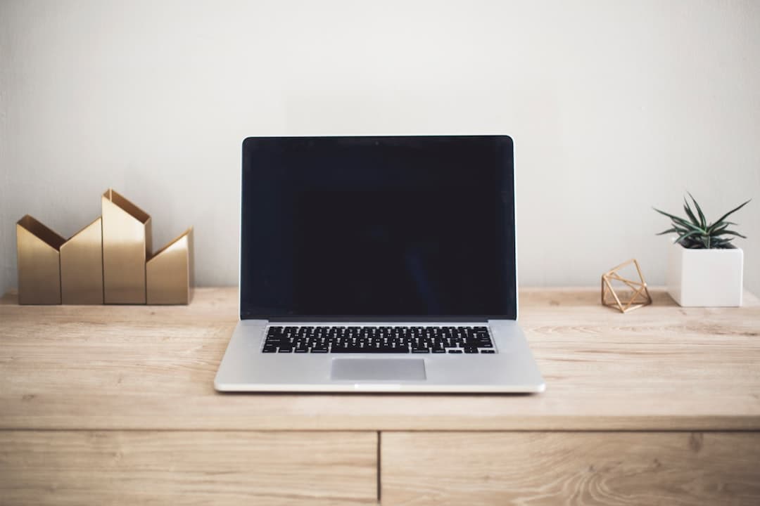 Faceless YouTube creator's desk with a laptop and decorative items, suggesting a workspace.