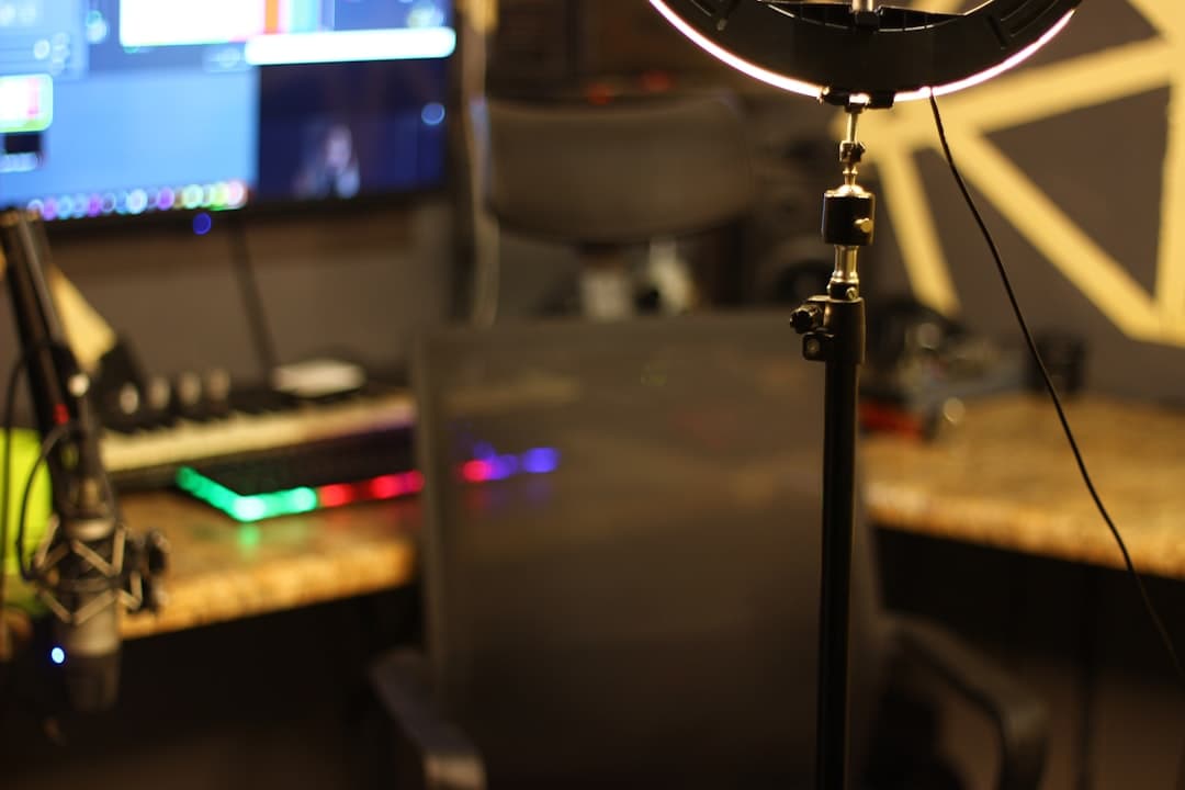 Faceless YouTube creator's studio setup with microphone, ring light, and computer monitor.