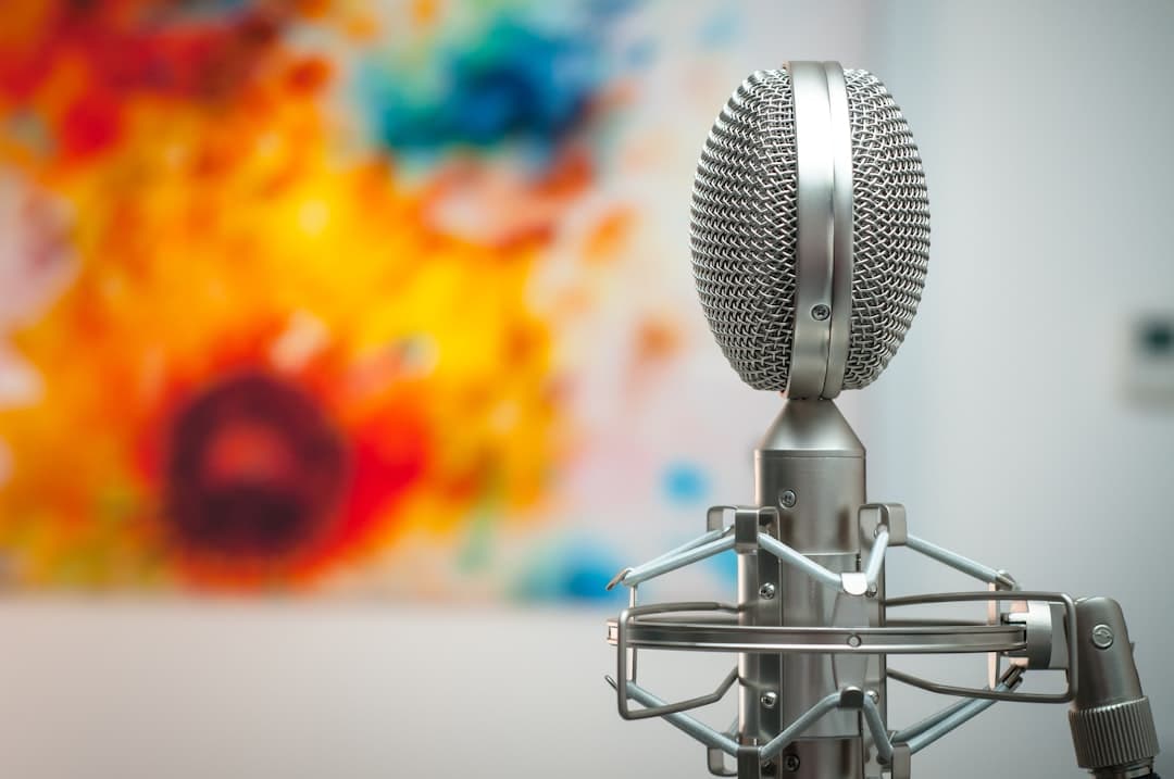 Retro microphone on a stand with a colorful abstract painting in the background.