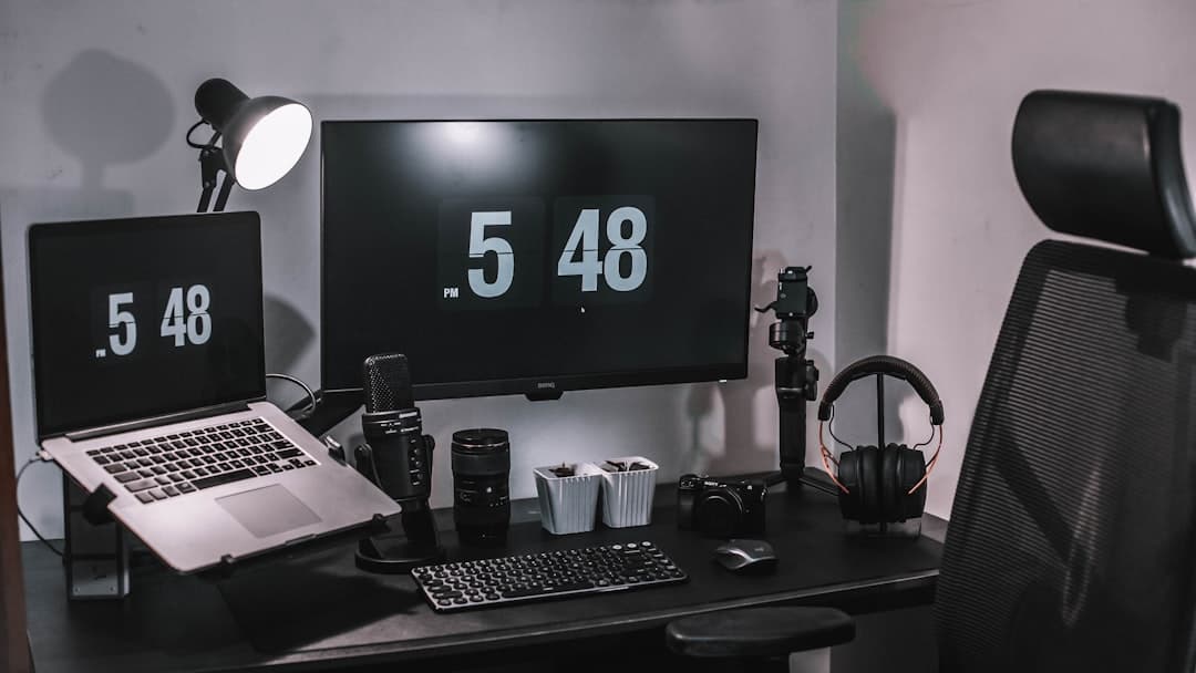 Faceless YouTube creator's desk setup with multiple monitors, microphones, and cameras for content creation.