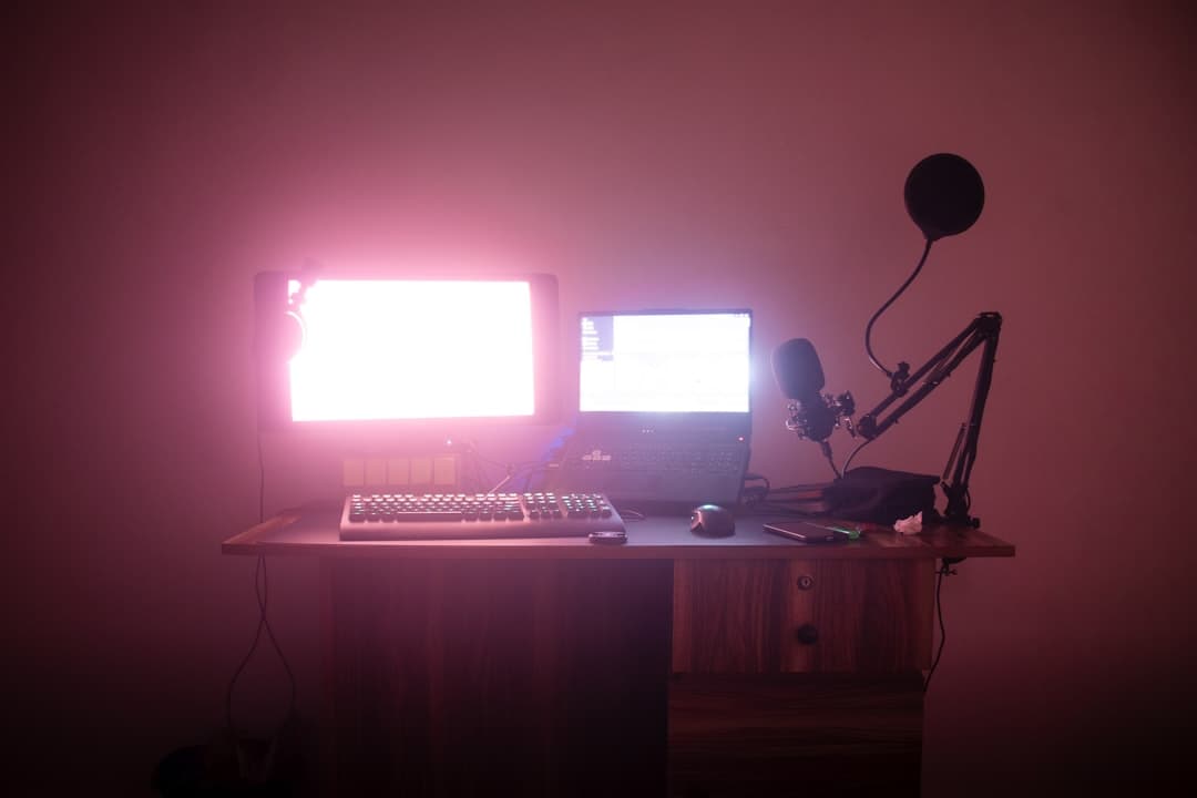 Desk setup with dual monitors, laptop, microphone, and keyboard for AI content creation workflow.
