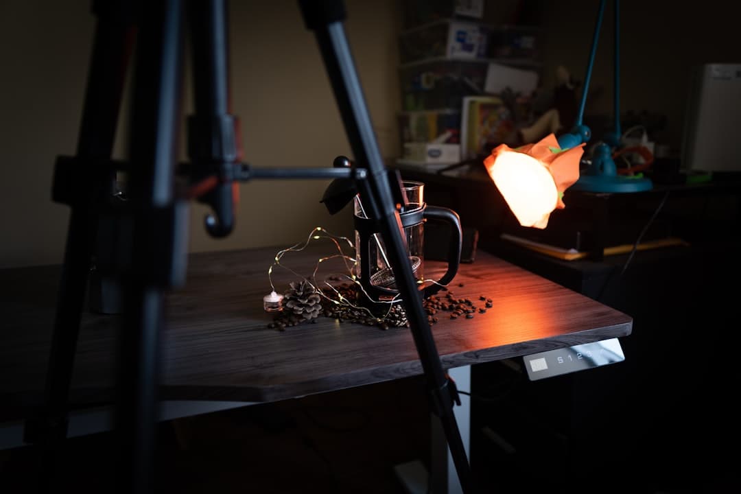 Faceless YouTube creator's setup with tripod, coffee setup, and lighting for content creation.