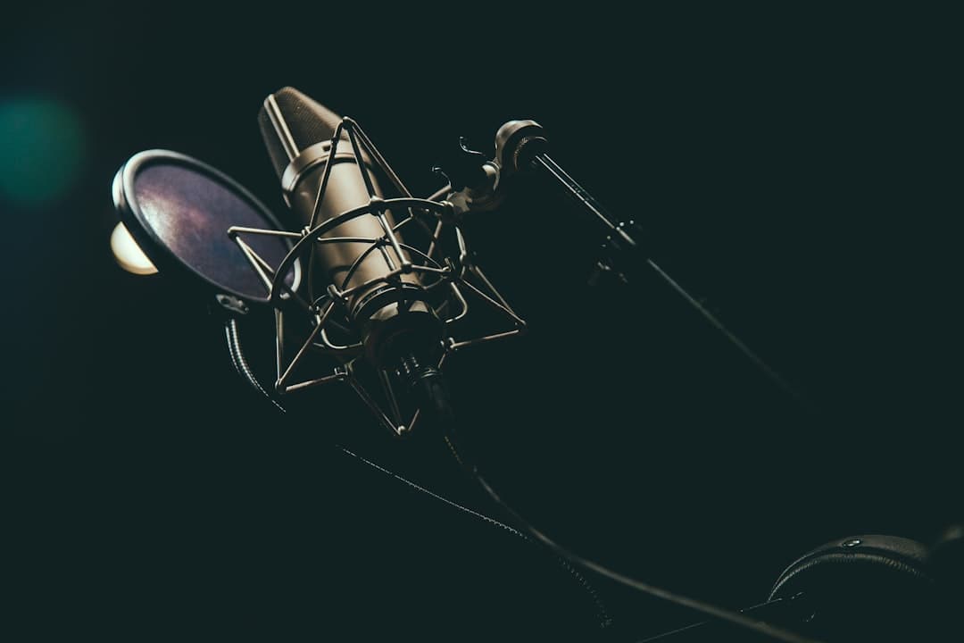 Professional microphone and pop filter in a dark studio setting for voiceover recording.