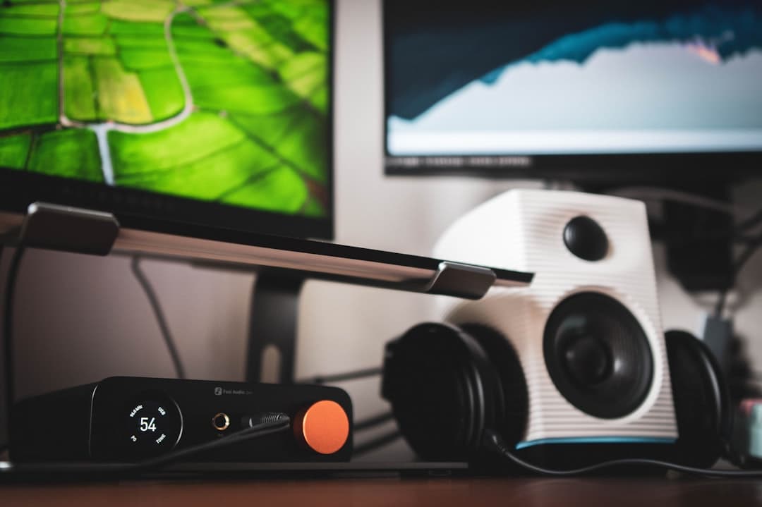 Close-up of audio equipment including headphones, speaker, and audio interface on a desk.
