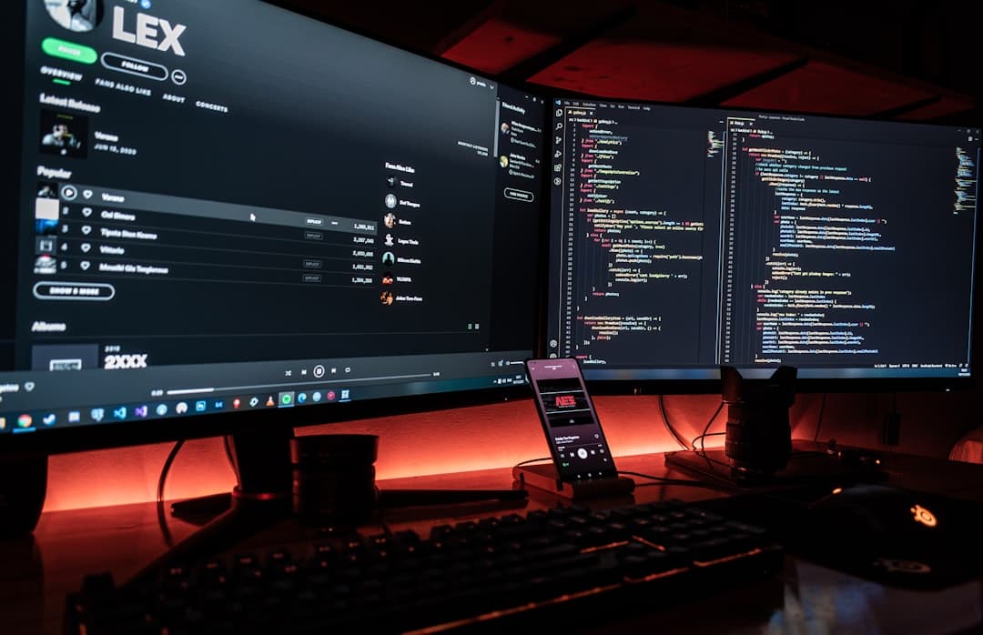 Dual monitors displaying code and YouTube analytics for faceless channel strategy.