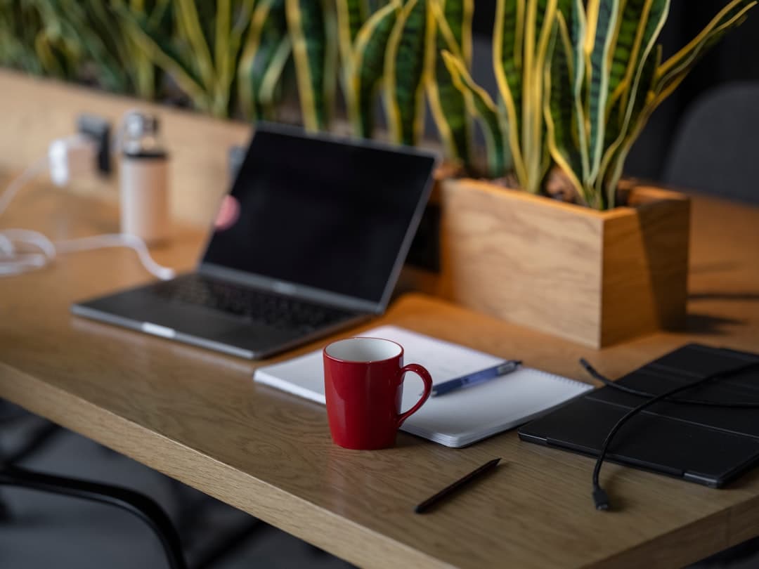 Faceless YouTube creator's desk with laptop, notebook, and coffee for AI niche research.