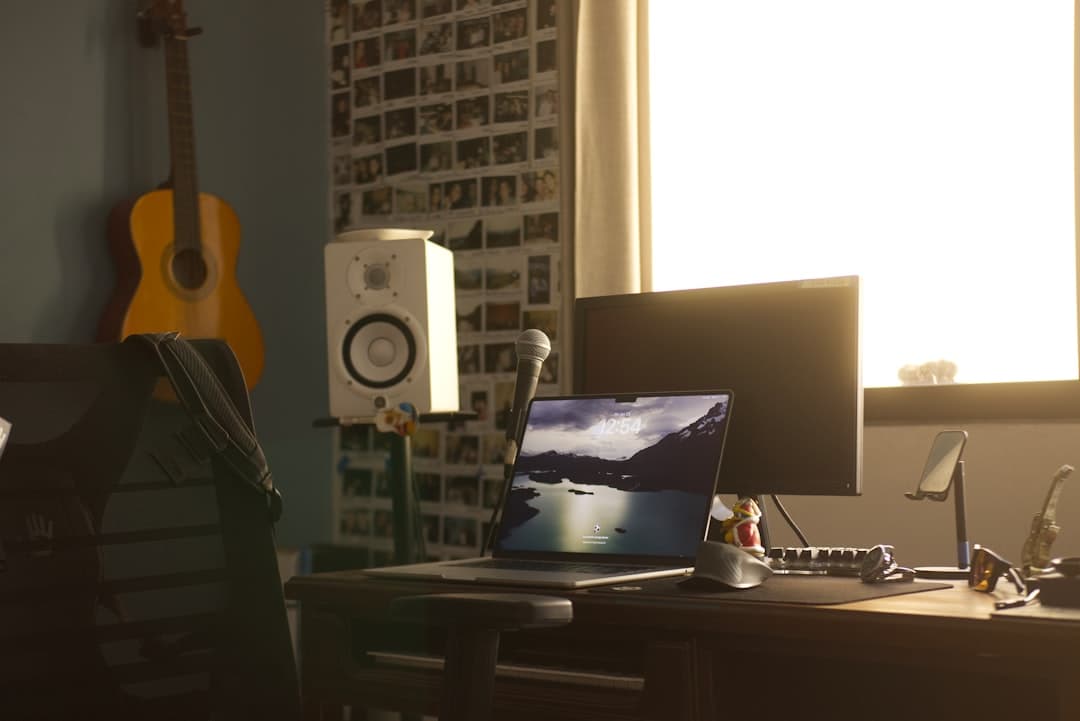 Faceless YouTube creator's desk with laptop, monitor, and microphone for AI tool workflow.