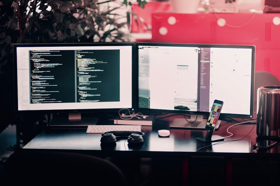 Dual monitors displaying code and analytics for faceless YouTube content strategy.