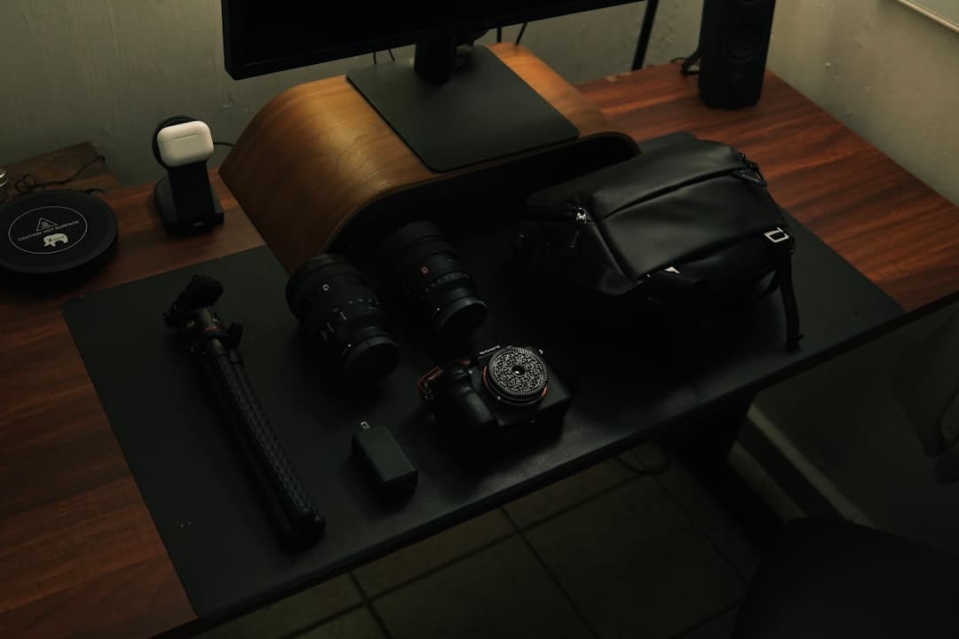 Faceless YouTube creator's camera gear and laptop on a desk for content creation.