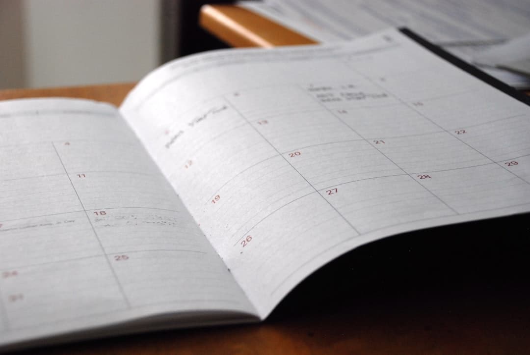 Open planner with calendar pages and handwritten notes for faceless YouTube content planning.