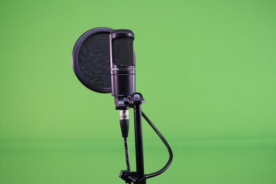 Studio microphone with pop filter on a green screen background for content creation.