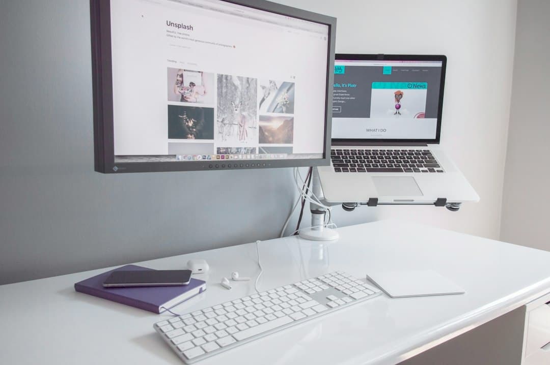 Faceless YouTube creator's desk with dual monitors showing website and stock photos, laptop, and keyboard.