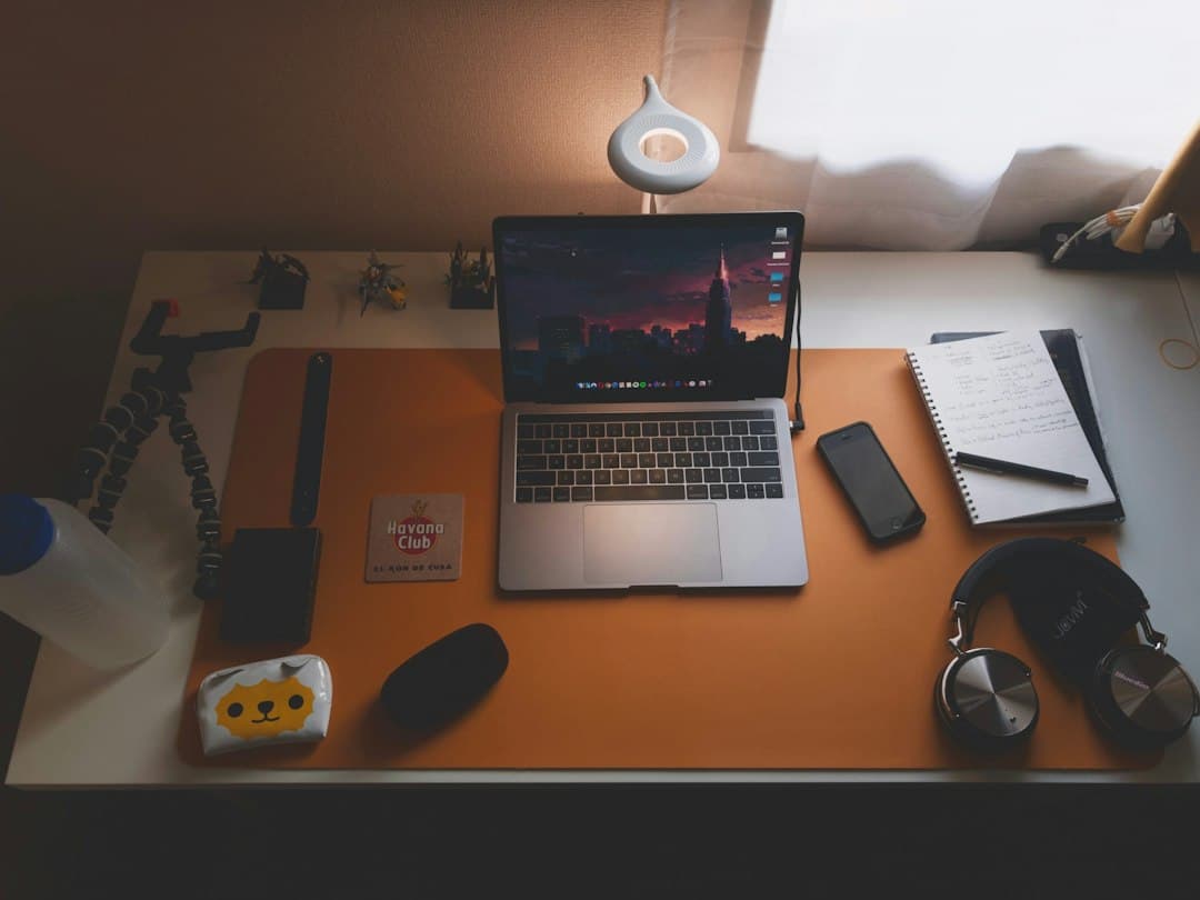 Faceless YouTube creator's desk with laptop showing video editing software and recording equipment.