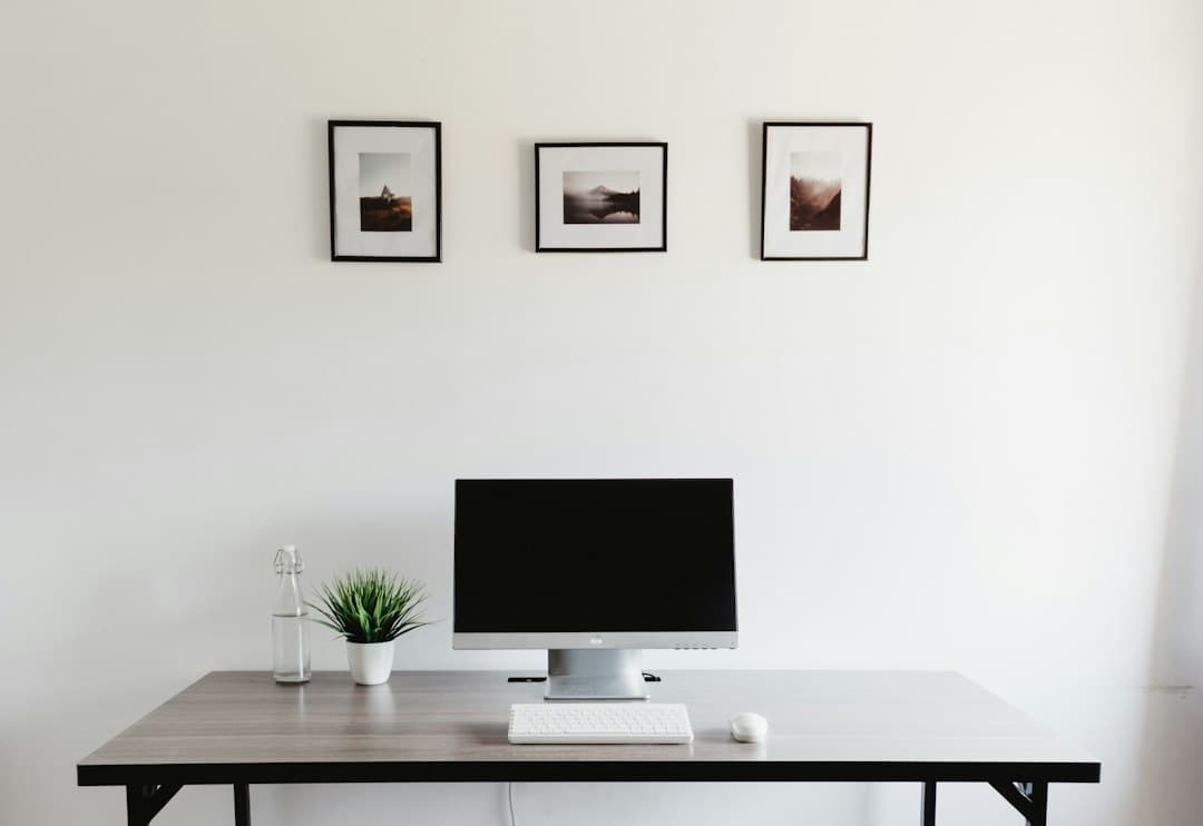 Empty desk with computer monitor and keyboard, ideal for faceless YouTube creator workspace.