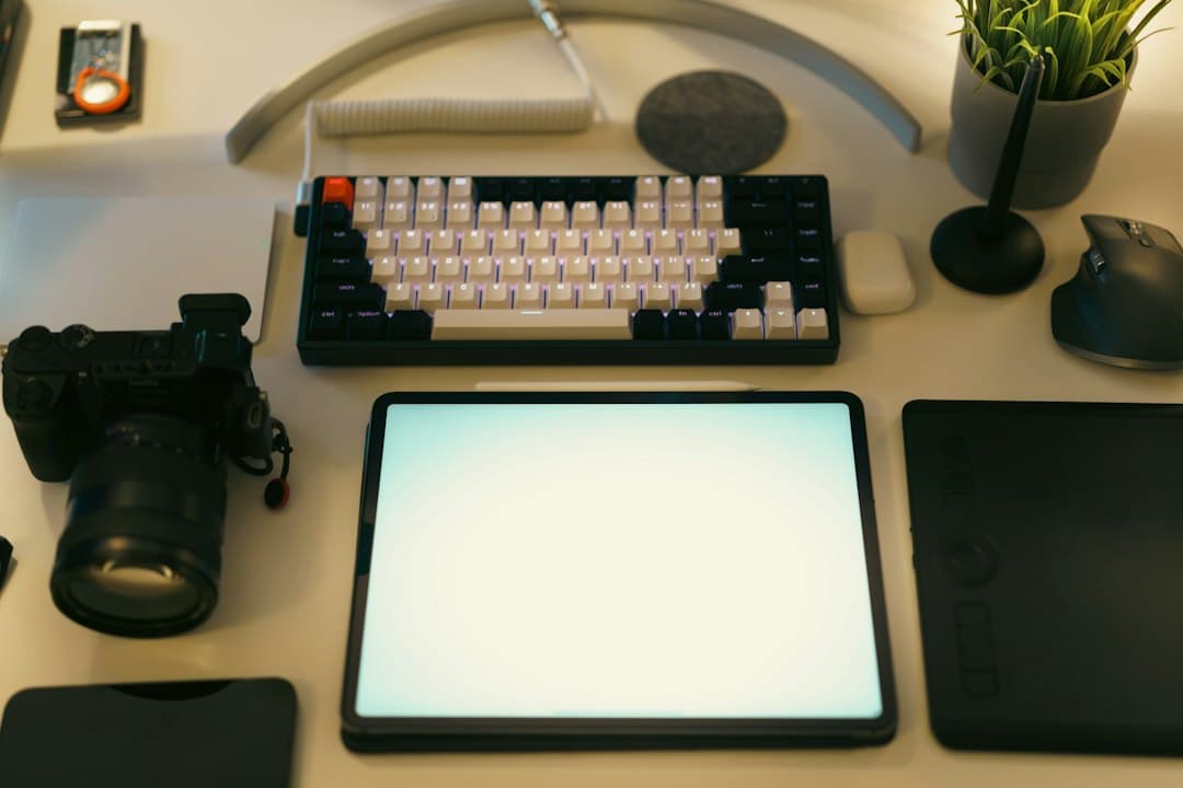 Faceless YouTube creator's desk with camera, tablet, and keyboard for visual content planning.